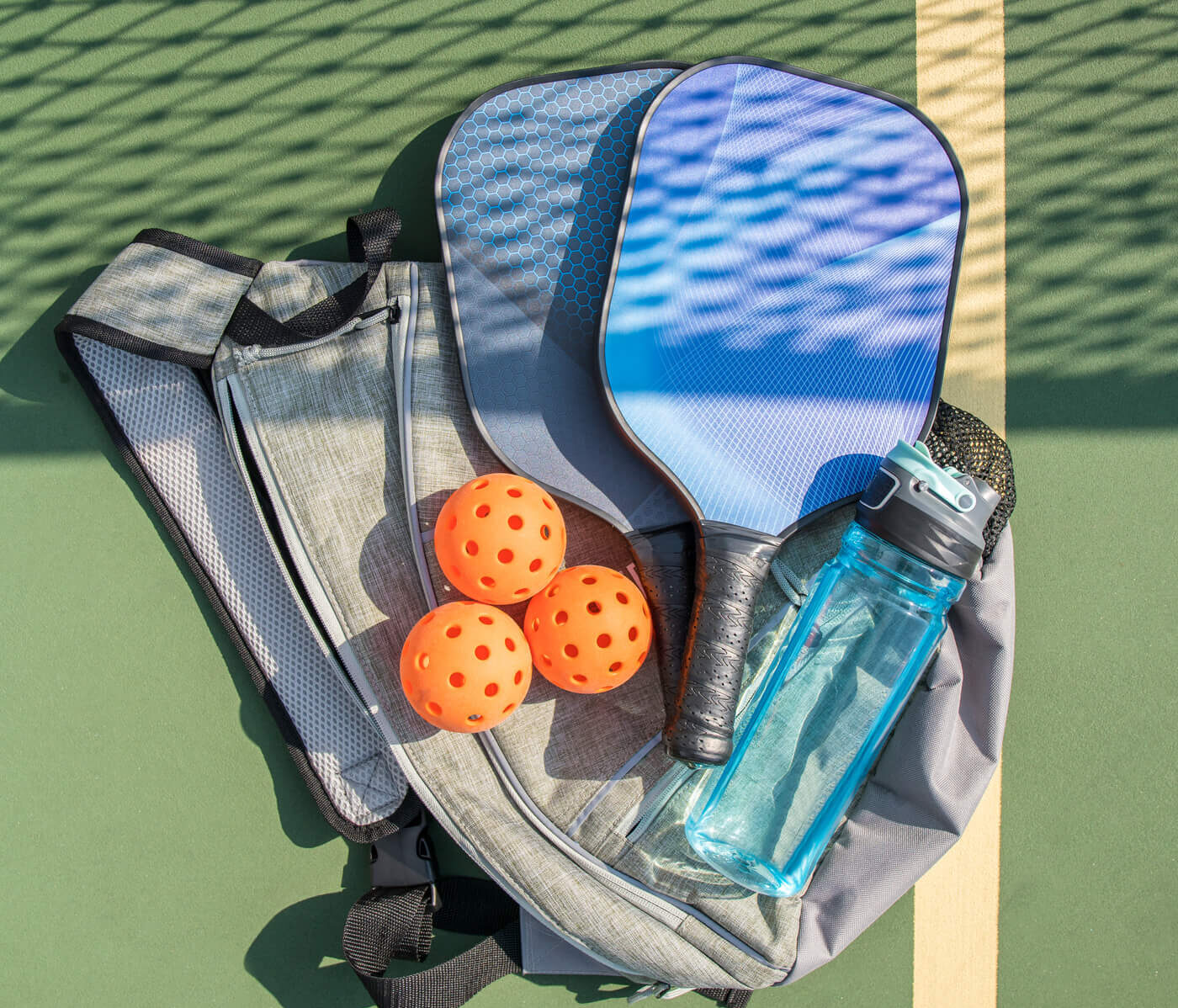Pickleball paddle, balls, bag and water bottle